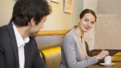 A woman and a man are flirting in a coffee shop